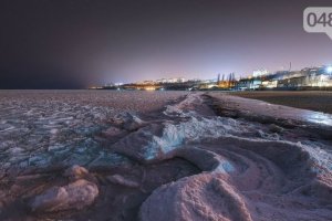 Los odesitas hacen fotos del mar nocturno cubierto de hielo