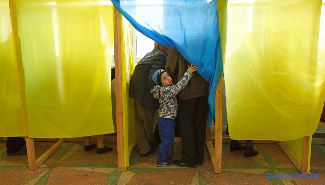 Избиратели стоят в кабине во время процедуры голосования