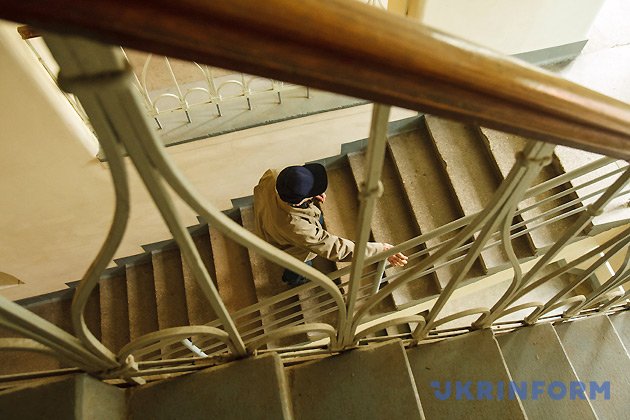 Годинникар Василь Дуфинець піднімається сходами до головного годинника на Мукачівській міській ратуші