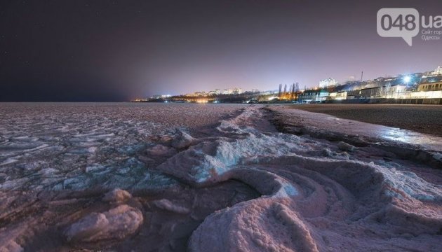 Los odesitas hacen fotos del mar nocturno cubierto de hielo 