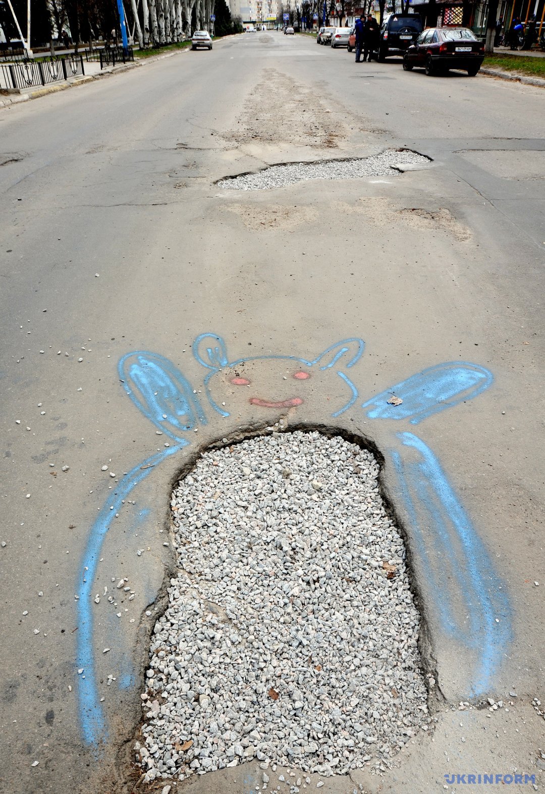 Каміння у ямі на дорозі та малюнок навколо неї під час флешмобу 