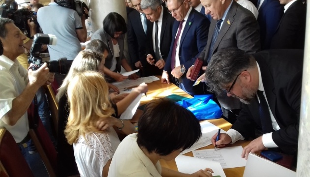 Депутати у кулуарах підписують присягу і отримують посвідчення Депутати у кулуарах підписують присягу і отримують посвідчення