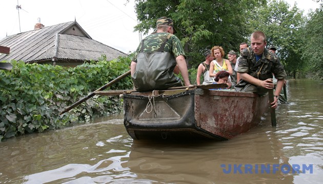 На фото: Співробітники МНС допомагають жителям Могильов-Подільського потрапити до своїх будинків та вивезти найнеобхідніші речі. Вінницька область, 30 липня 2008 року