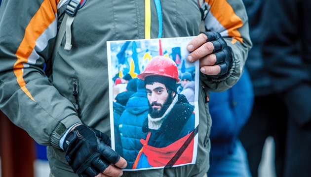 Мітингувальник тримає портрет Сергія Нігояна. Фото: Укрінформ