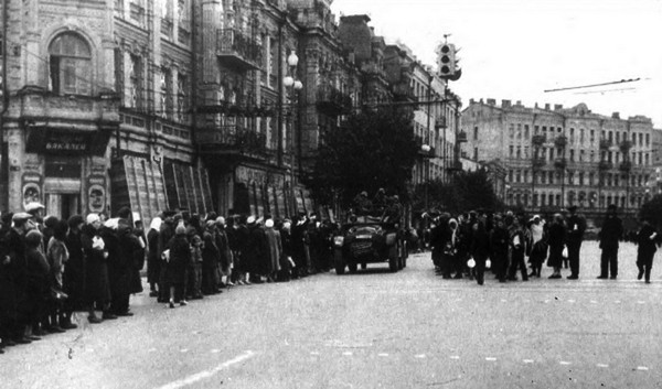 Кияни спостерігають за німецькими солдатами, які щойно вступили до міста, на розі вул. Великої Васильківської та Бессарабської площі, 19 вересня 1941 року. Джерело: фотоальбом 