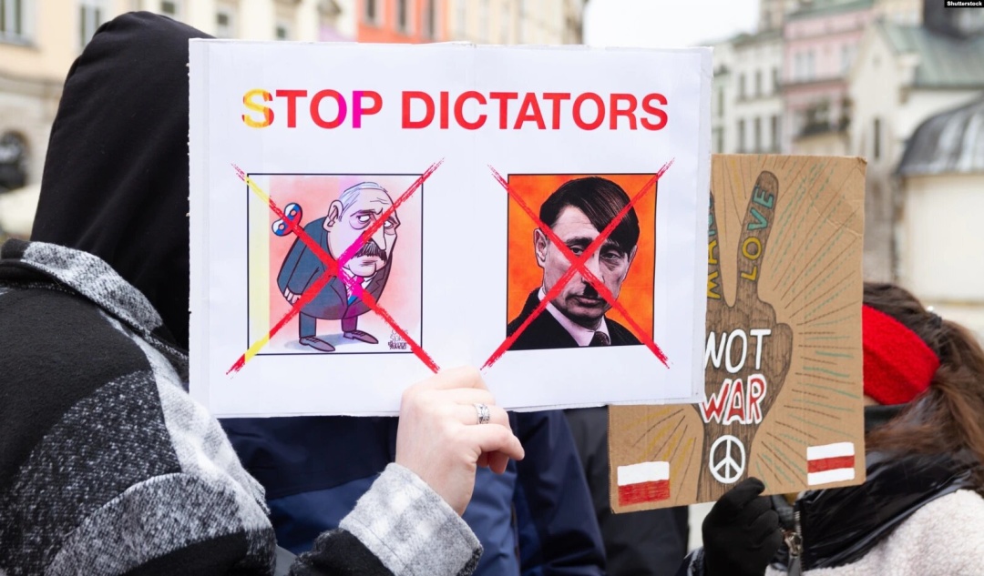 Плакат «Стоп диктаторам» із зображенням Володимира Путіна і Олександра Лукашенка під час акції протесту проти вторгнення Росії до України. Краків, Польща, 6 березня 2022 року