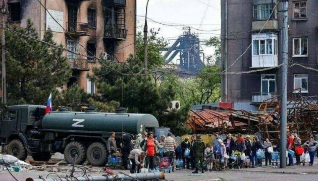 Росіяни в Маріуполі роздають гуманітарку на місці, де торік звалювали тіла вбитих цивільних