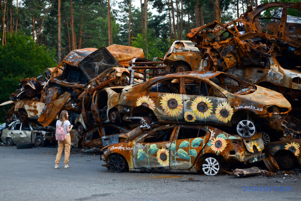 Соняшники на знищених росіянами автомобілях в Ірпені / Фото: Олександра Бутова, Укрінформ