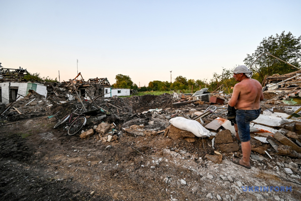 Чоловік збирає уцілілі речі на руїнах свого будинку в Чаплиному, знищеного російською ракетою / Фото: Дмитро Смольєнко, Укрінформ