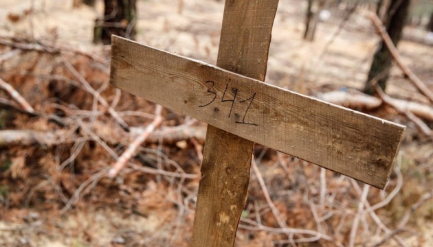 Понівечена рука з двома синьо-жовтими браслетами