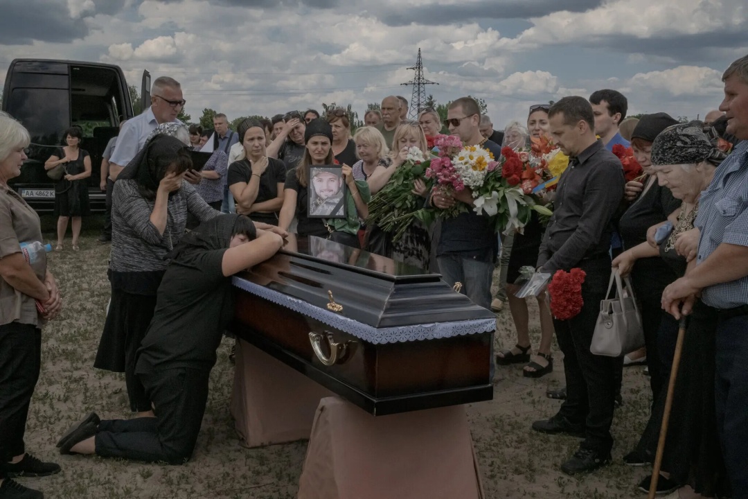 Олена Іванівна прощається зі своїм сином на кладовищі в Бортничах / Фото: Mauricio Lima/The New York Times