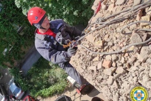 На Печерську рятувальники розбирають аварійні конструкції на даху пошкодженої багатоповерхівки