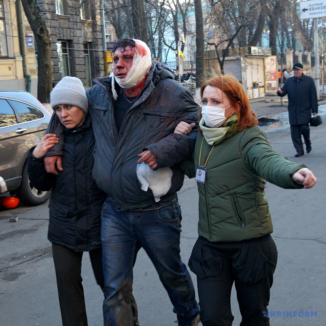 Жінки ведуть постраждалого протестувальника під час сутичок на вулиці Інститутській, Київ, 18 лютого 2014 року. / Фото: Павло Багмут