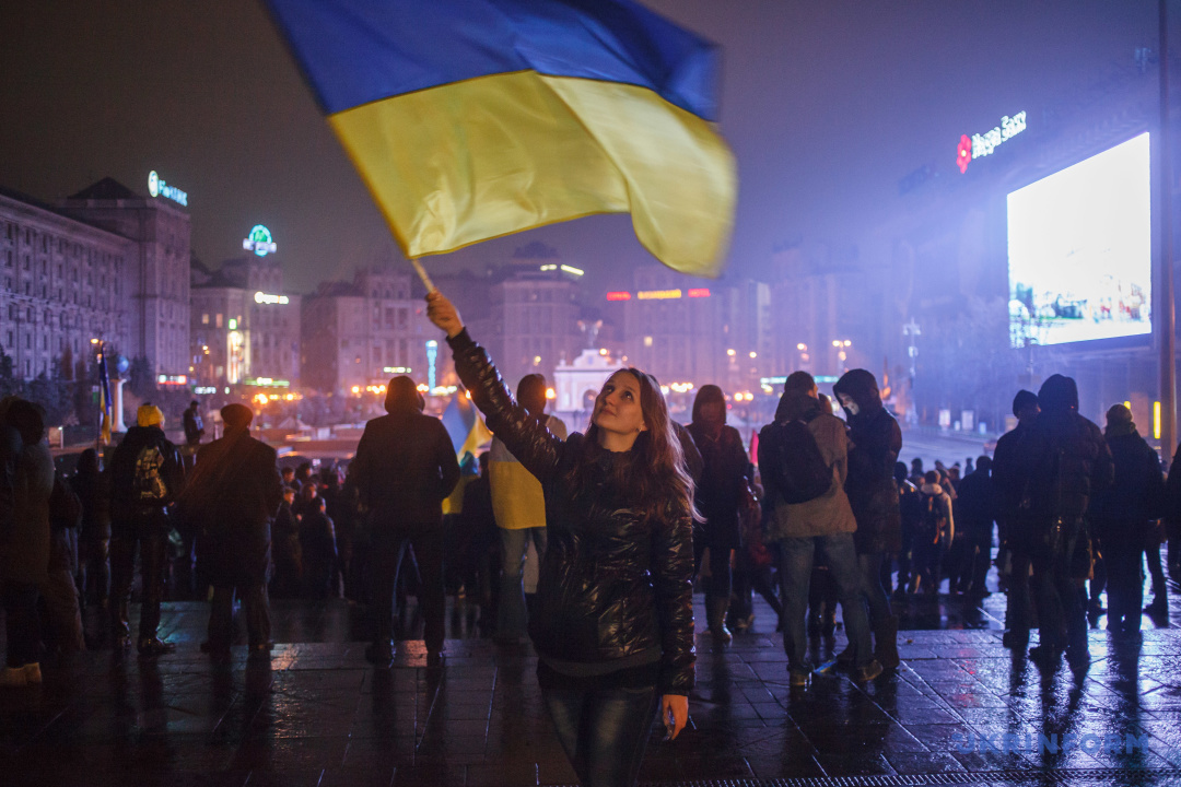 Une participante à la manifestation de protestation des Ukrainiens indignés par la décision du gouvernement ukrainien de suspendre la préparation de l'accord d'association avec l'Union européenne tient le drapeau national, Kyiv, le 22 novembre 2013. / Photo : Oleksandr Kosmach