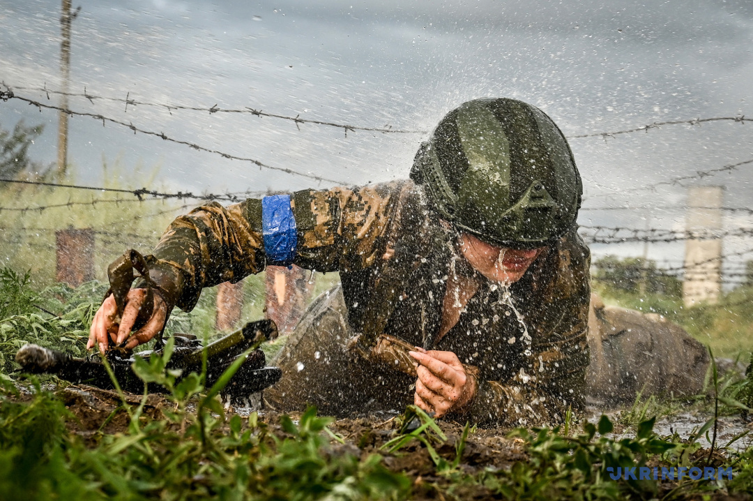 Foto: Dmytro Smoljenko  Eine Soldatin der 128. separaten Transkarpatischen Bergsturmbrigade durchläuft im Rahmen eines Tests einen Hindernisparcours und erhält anschließend eine Baskenmütze mit einer Edelweißblume, Region Saporischschja, den 14. Juli 2023.