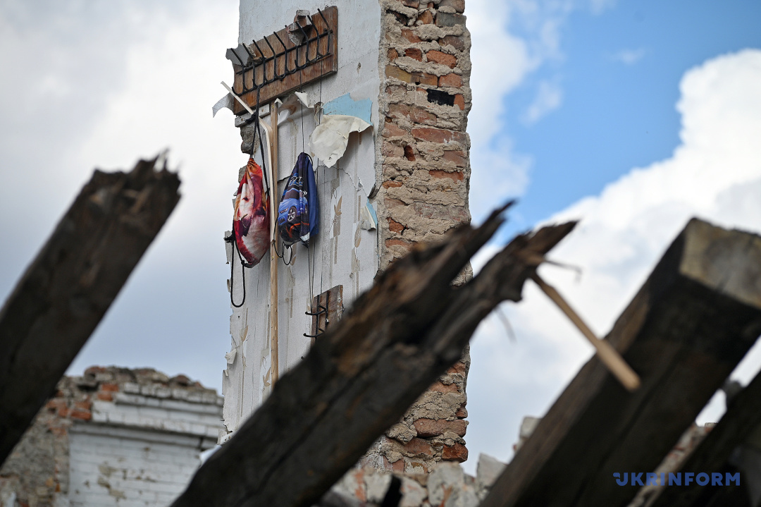 Foto: Dmytro Smoljenko  Kindersportrucksäcke hängen an der nach dem russischen Beschuss ganz gebliebenen Wand eines Wohngebäudes in der Frontstadt Orichiw in der Region Saporischschja, den 7. September 2023