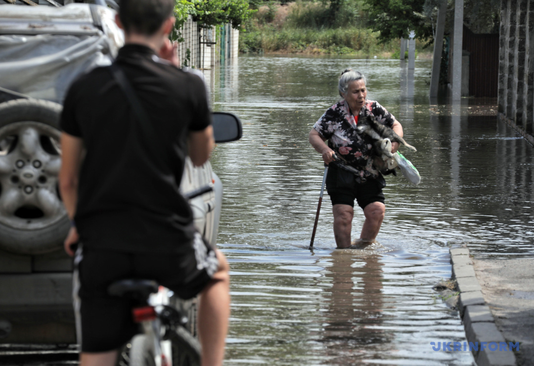 Kobieta idzie ulicą miasta Chersoń, 6 czerwca 2023 r., zalanego w wyniku podważenia tamy przez wojska rosyjskie Kachowskiej Elektrowni Wodnej.