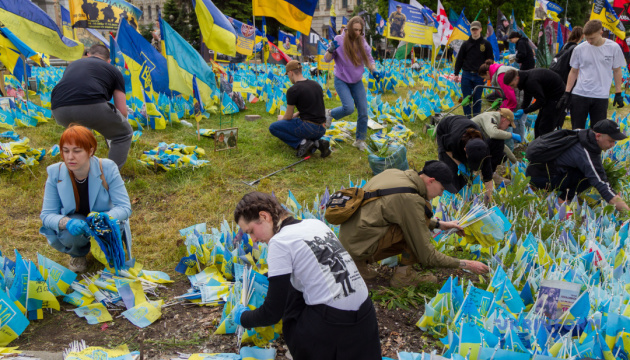 Activists next to the flags with the names of fallen Ukrainian defenders on Independence Square in Kyiv / Photo: Kyrylo Chubotin/Ukrinform