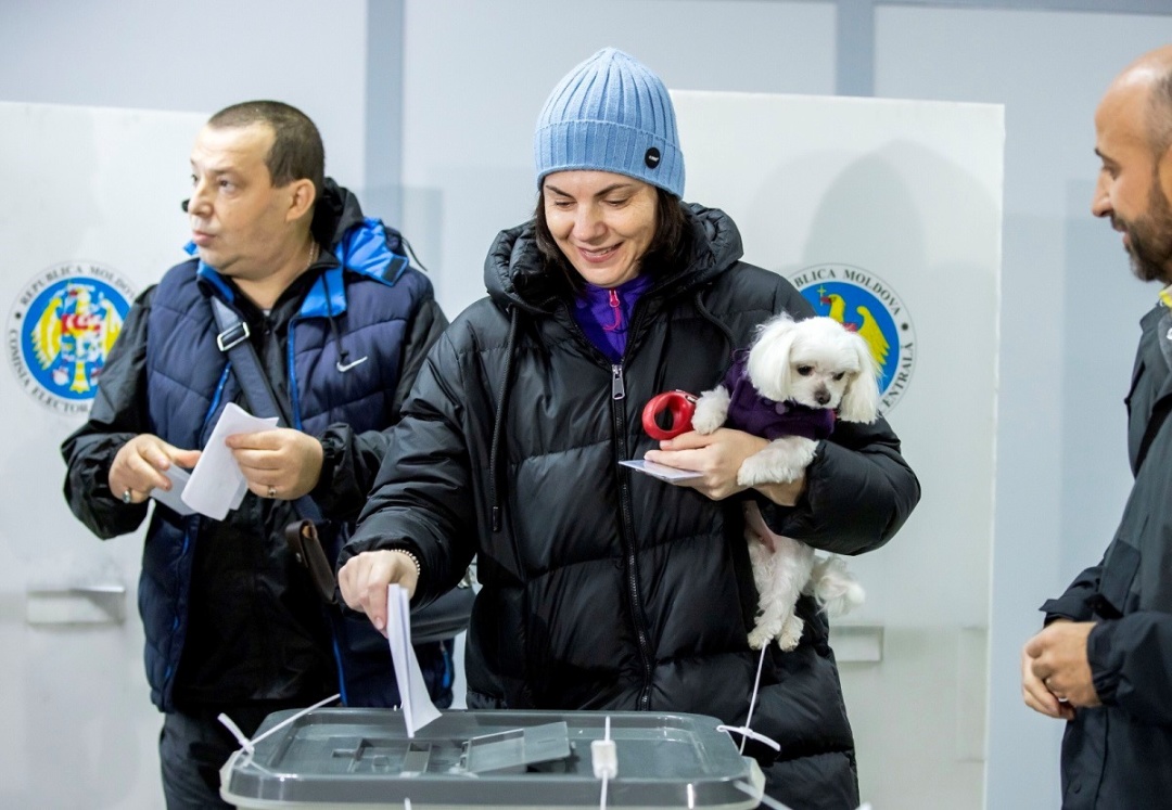 Жінка з собакою голосує на виборчій дільниці в Кишиневі. Фото: PAP/EPA/DUMITRU DORU