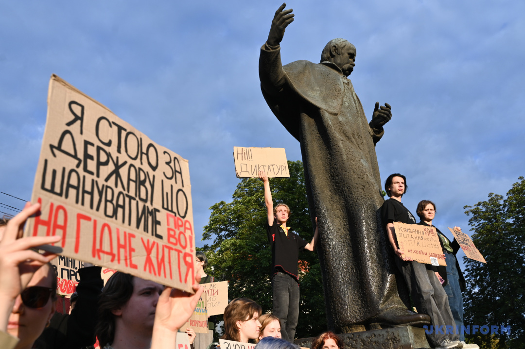 Активісти тримають у руках плакати з гаслами під час мітингу, організованого на підтримку незалежності НАБУ і САП, на площі біля пам’ятника Тарасу Шевченку, Львів, 30 липня 2025 року. Фото Анастасії Смольєнко