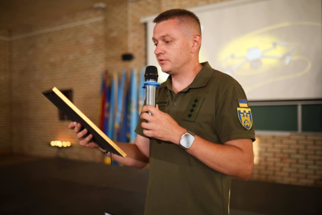 Військовослужбовець ЗСУ Богдан Бень вручає відзнаки сумівцям від командувача Сухопутних військ.