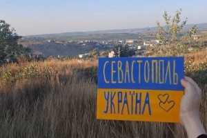 ロシア占領地でウクライナの活動家がウクライナ国旗を示す