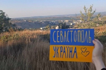 ロシア占領地でウクライナの活動家がウクライナ国旗を示す