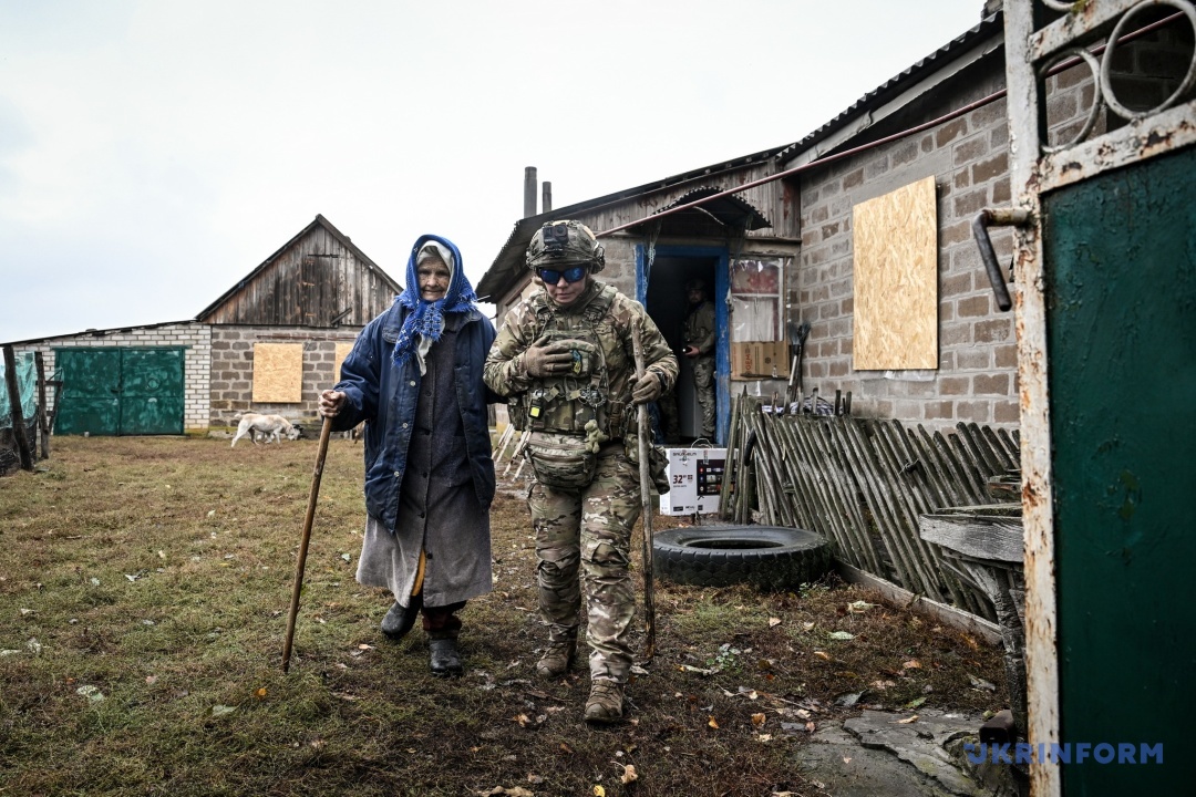 Христина веде до евакуаційного авто пані Явдоху, якій 94 роки
