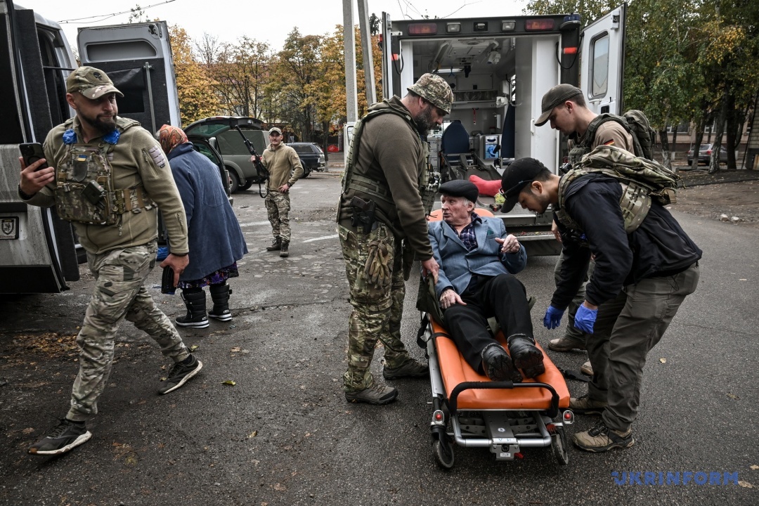Волонтери перевантажують людей до свого авто аби відвезти в транзитний центр