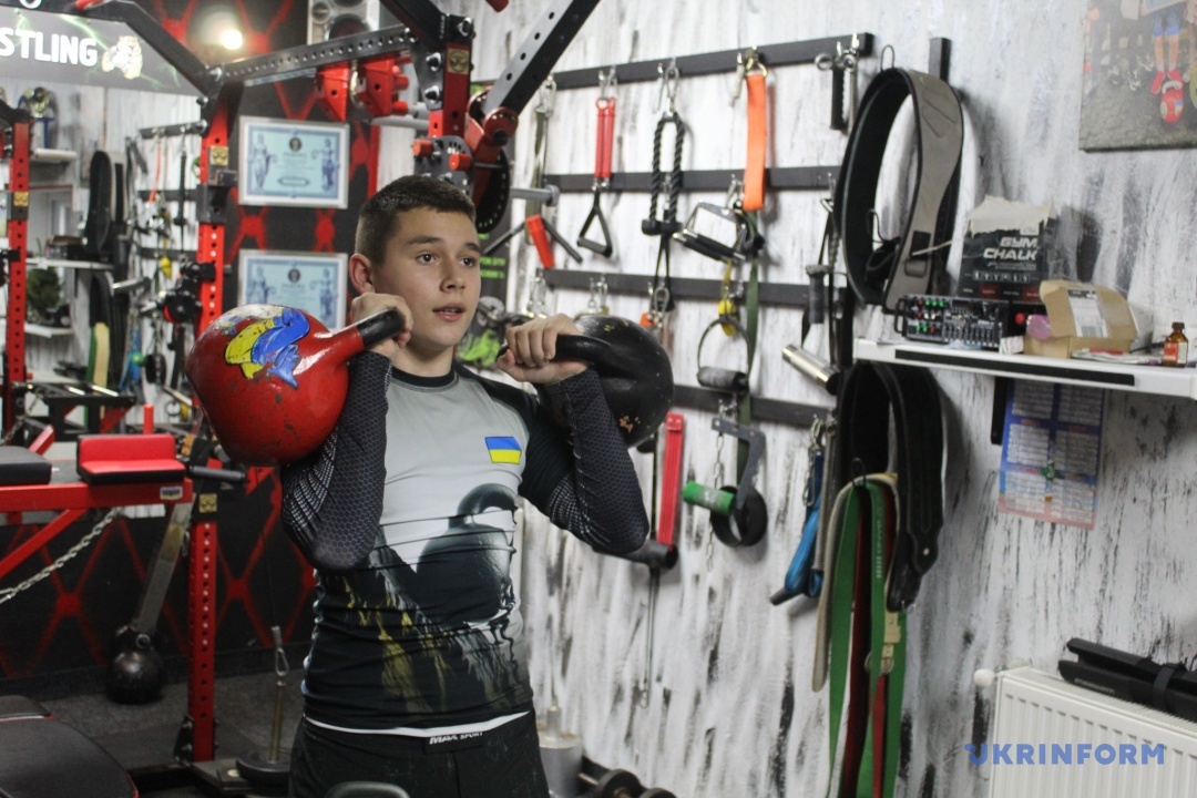 В руках у хлопця гирі - одна 24 кг, друга - 32 кг