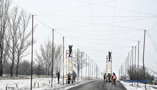 На Донеччині військові встановлюють антидронові сітки вздовж дороги для захисту транспортних засобів від атак російських FPV-дронів / Фото: Дмитро Смольєнко, Укрінформ