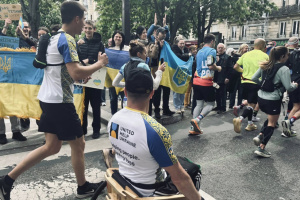 Ukrainian team of veterans and civilians in wooden wheelchairs takes part in Paris Marathon