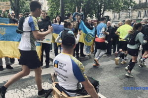 Ukrainian team of veterans and civilians in wooden wheelchairs takes part in Paris Marathon