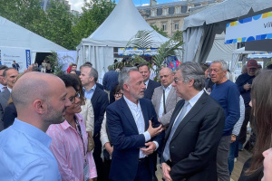 Paris mayor tries Petrykivka painting at Ukrainian stand during Europe Day celebration