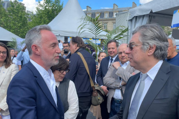 Paris mayor tries Petrykivka painting at Ukrainian stand during Europe Day celebration