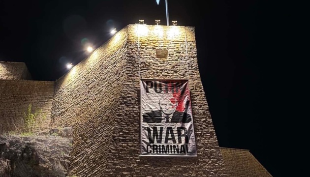 В Естонії на стіні Нарвського замку вивісили плакат «Путін - військовий злочинець»