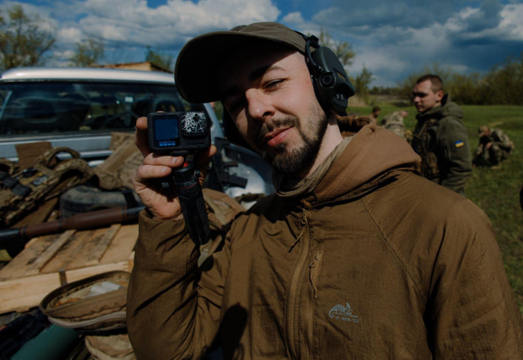 Оператор відділення комунікацій 24 бригади тримає в руках GoPro, розбиту на зйомці під час вибуху машини. Донеччина, 2026 рік. Фото: Іван Петричак